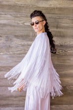 Load image into Gallery viewer, Person wearing a white fringe outfit against a wooden wall.