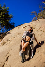 Load image into Gallery viewer, Person posing on a rocky outcrop with a clear blue sky