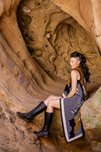 Load image into Gallery viewer, Woman sitting inside a natural rock formation