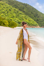 Load image into Gallery viewer, Woman on a beach with a yellow patterned cover-up and white swimsuit.