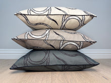 Load image into Gallery viewer, Three decorative pillows with a geometric pattern stacked on a wooden surface.