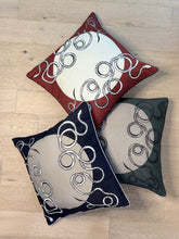 Load image into Gallery viewer, Three decorative pillows with circular patterns on a wooden floor.