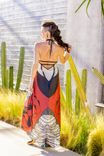 Load image into Gallery viewer, Woman in a colorful dress standing outdoors with plants and a white wall in the background