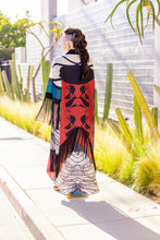 Load image into Gallery viewer, Woman wearing a colorful patterned dress with a red and black design, standing outdoors.