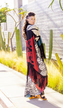 Load image into Gallery viewer, Woman wearing a colorful dress with fringe in an outdoor setting