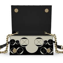 Load image into Gallery viewer, Black handbag with geometric patterns and gold accents on a white background