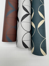 Load image into Gallery viewer, Three rolls of patterned wallpaper in brown, white, and blue on a light gray background