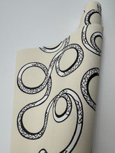 Load image into Gallery viewer, Roll of wallpaper with black snake pattern on beige background