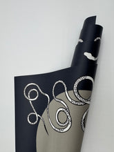 Load image into Gallery viewer, Roll of black paper with white scissors design on a light gray background