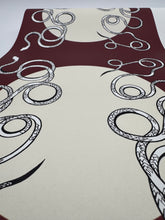 Load image into Gallery viewer, Decorative tablecloth with black curly patterns on a red and beige background