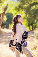 Load image into Gallery viewer, Woman wearing a patterned cape walking through a sunlit forest