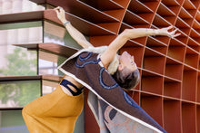 Load image into Gallery viewer, Person in a yellow dress and blue shoes posing with a long, patterned fabric against a modern architectural background.
