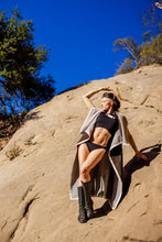 Load image into Gallery viewer, Person posing on a rocky hillside with a clear blue sky
