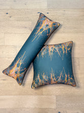Load image into Gallery viewer, Two decorative pillows with a blue and orange abstract pattern on a wooden floor.
