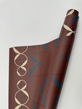 Load image into Gallery viewer, Roll of brown paper with geometric patterns on a white background
