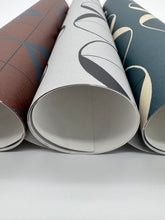 Load image into Gallery viewer, Three rolls of patterned wallpaper on a light gray background
