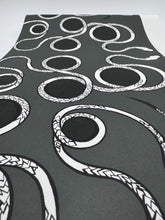 Load image into Gallery viewer, Yoga mat with black and white snake pattern on a gray background
