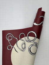 Load image into Gallery viewer, Roll of maroon paper with black scissors design on a white background
