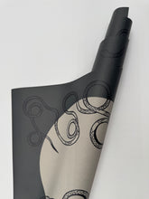 Load image into Gallery viewer, Roll of black and beige patterned paper on a white background
